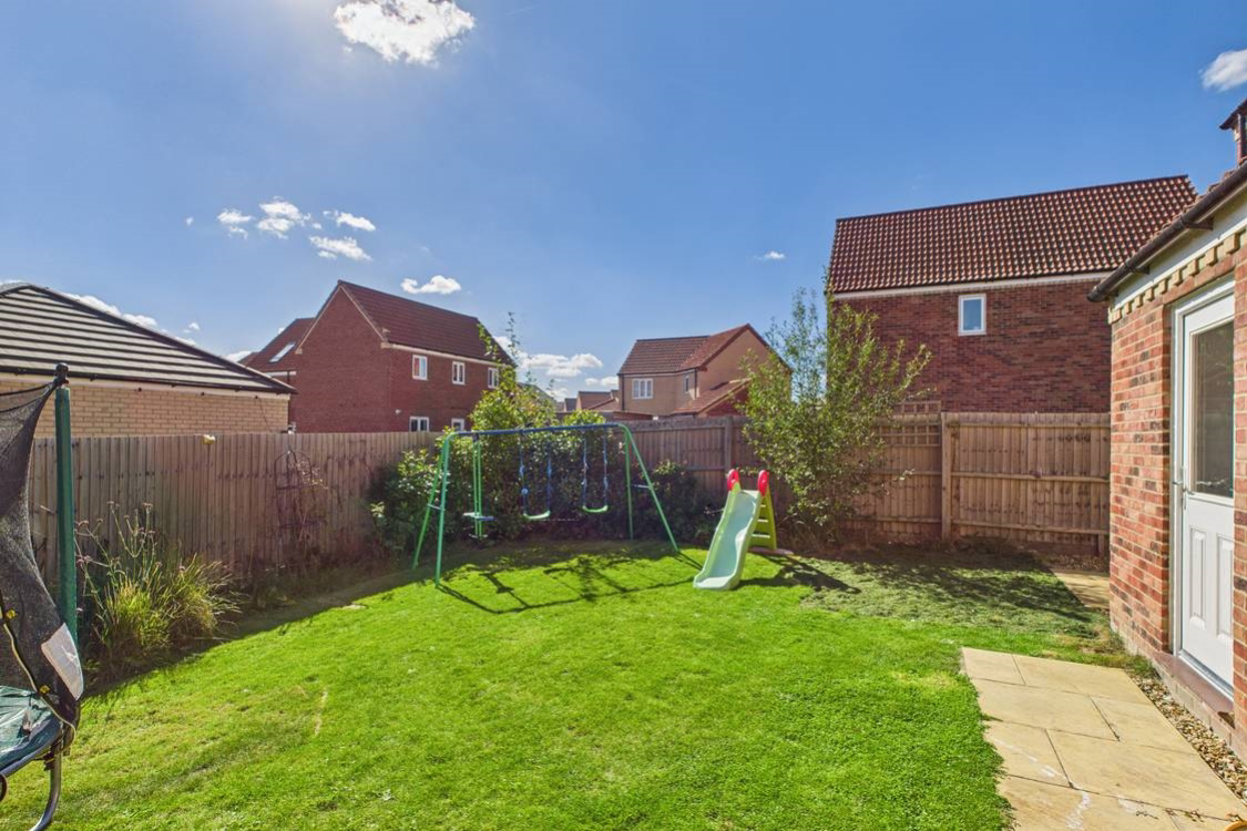 A path and patio at the back of the house make this practical space the perfect place to play or relax