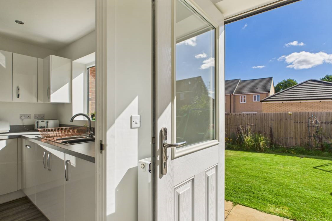 Ultra practical utility room with shelving sink and washing machine leaving the kitchen clutter free