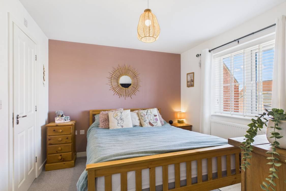The main bedroom with its large window is the perfect place to relax after a long day